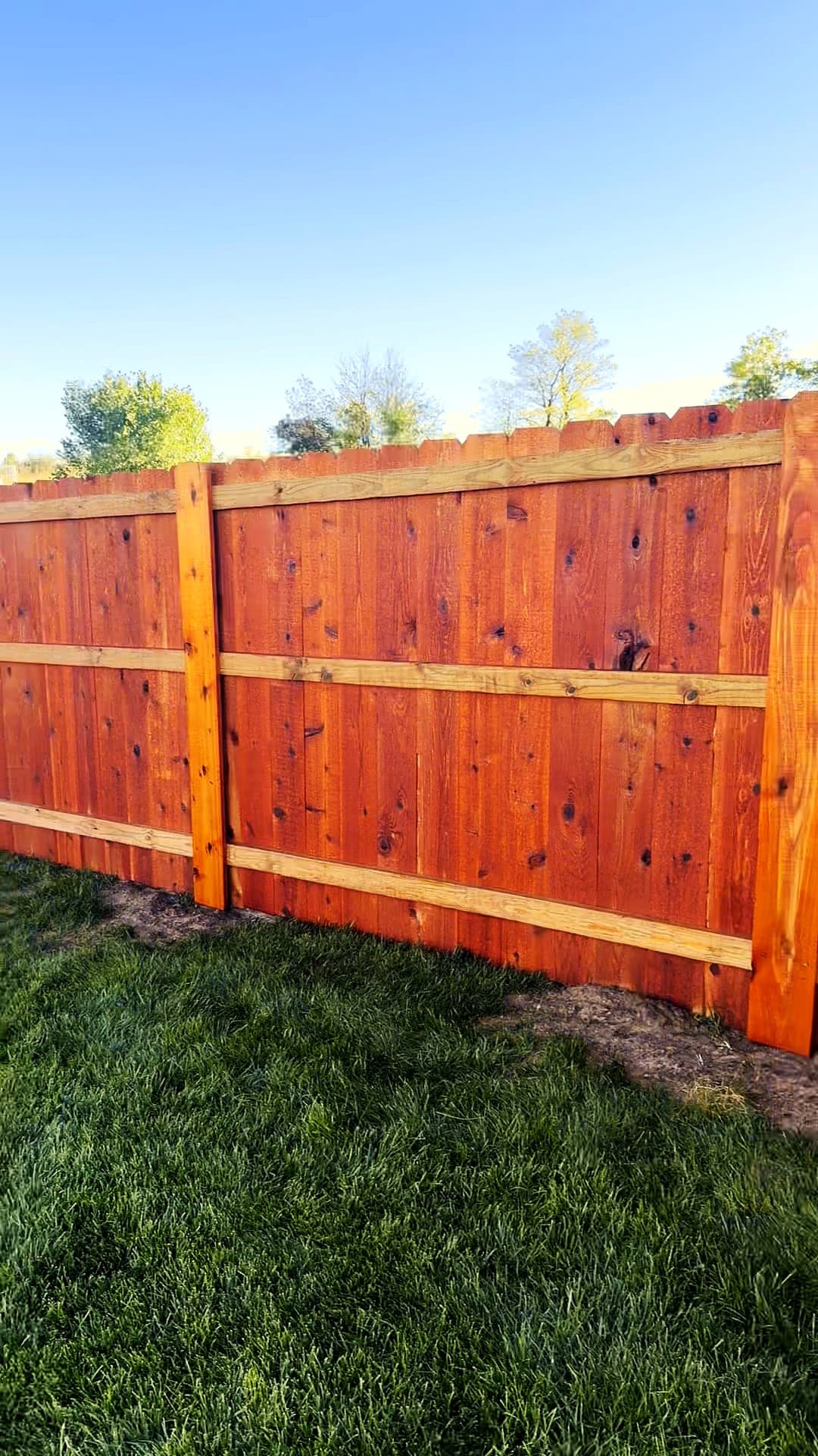 Rails and posts on the inside of a stained cedar privacy fence in Maize, Kansas