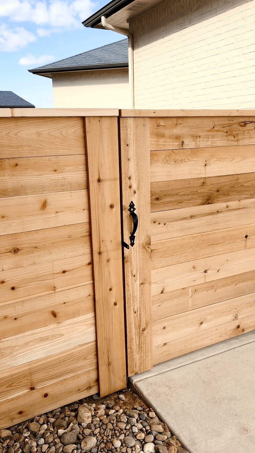 Black pull handle on a horizontal cedar gate, in Andale, Kansas